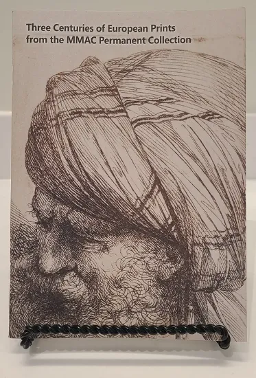 three centuries of european prints book resting on a bookstand with a line drawing of a man wearing a turban on the cover