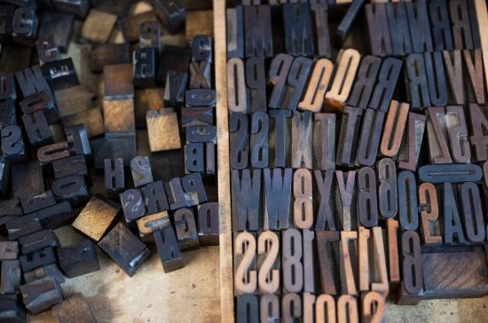 top view of a drawer full of printer press letters and numbers blackened with ink